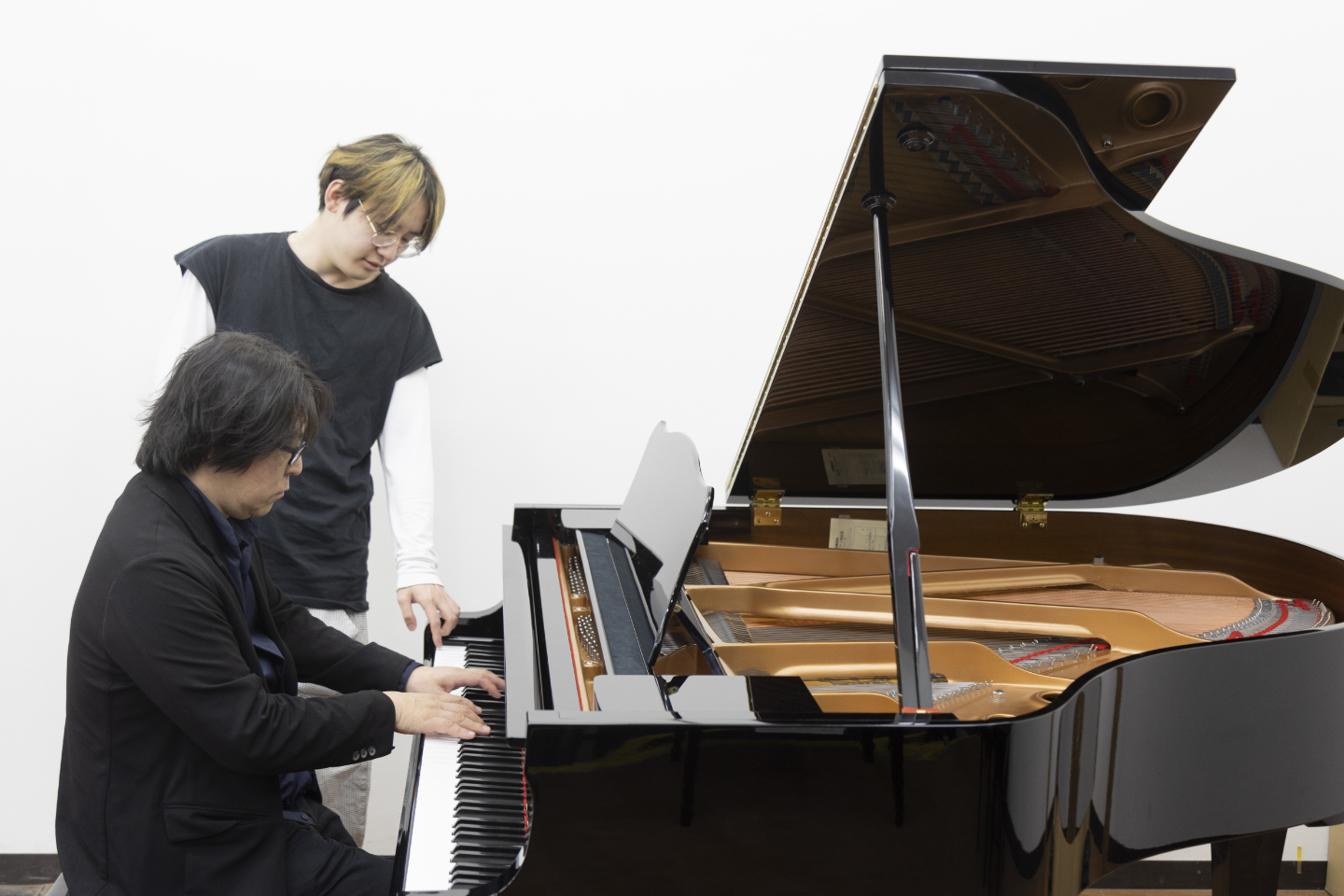 リニューアルプランが完了したピアノを弾く安部潤さん（手前）と安部和奏さん